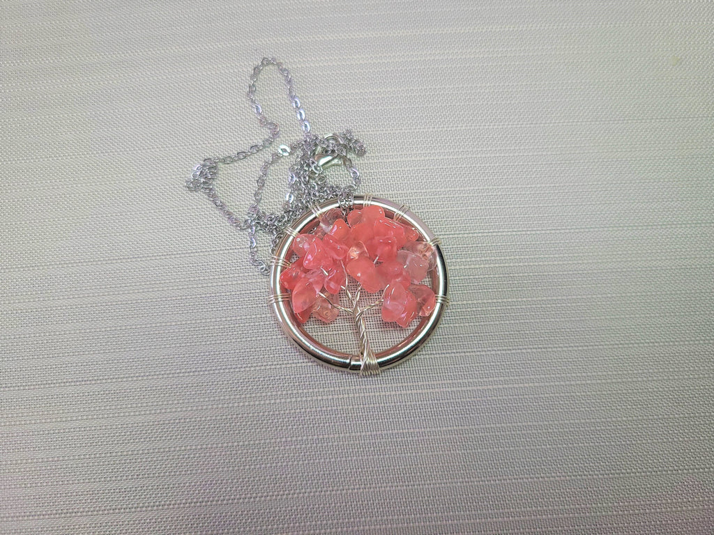 Necklace with a round pendant featuring pink beads on a gray background