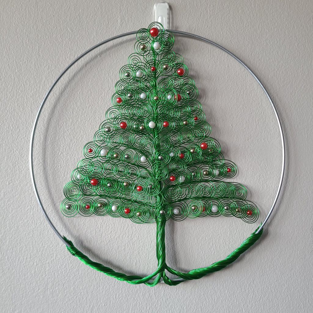 Decorative green leaf ornament with red and white details on a gray background
