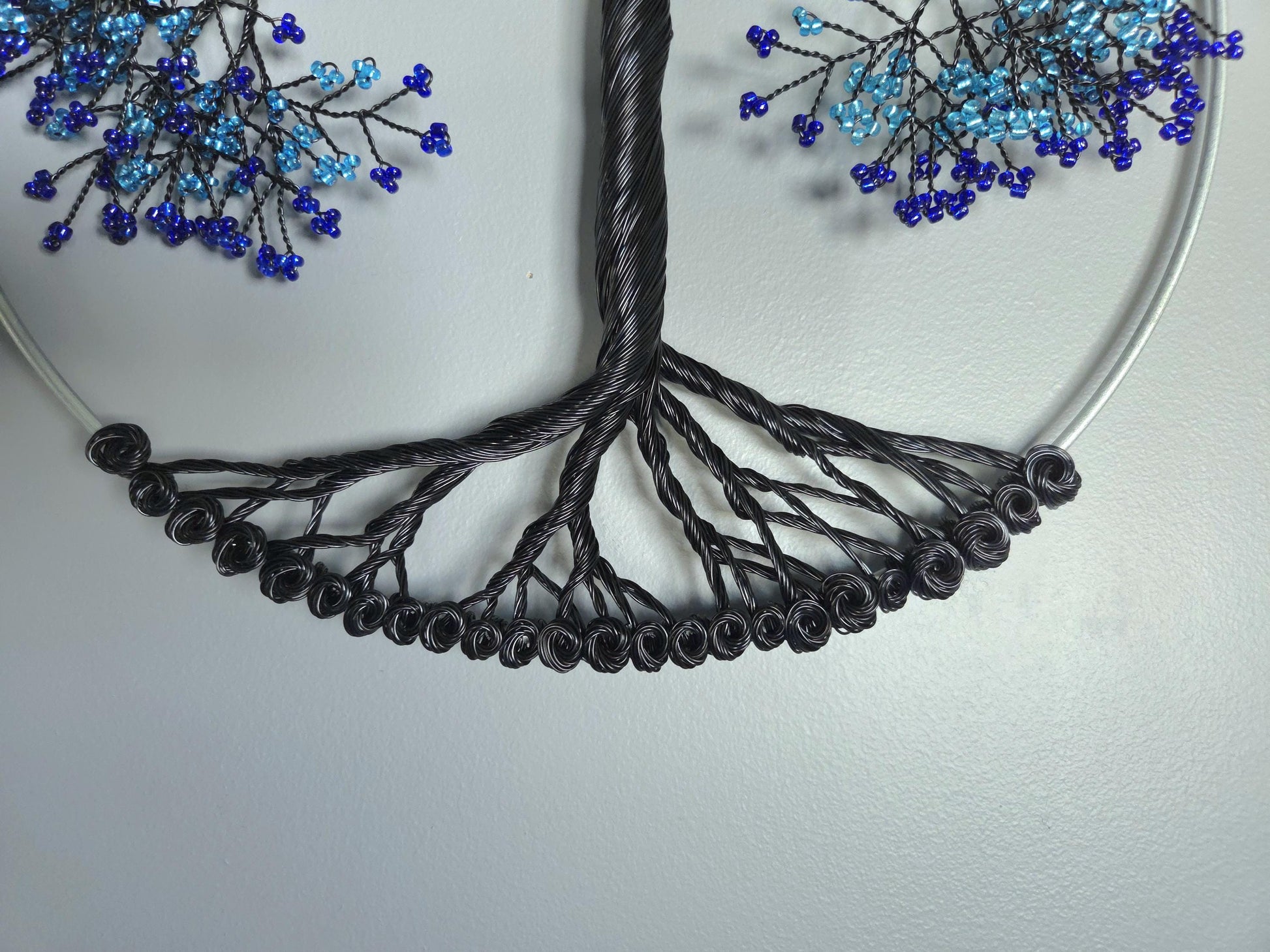 Necklace with black cord and blue bead decorations on a light gray background