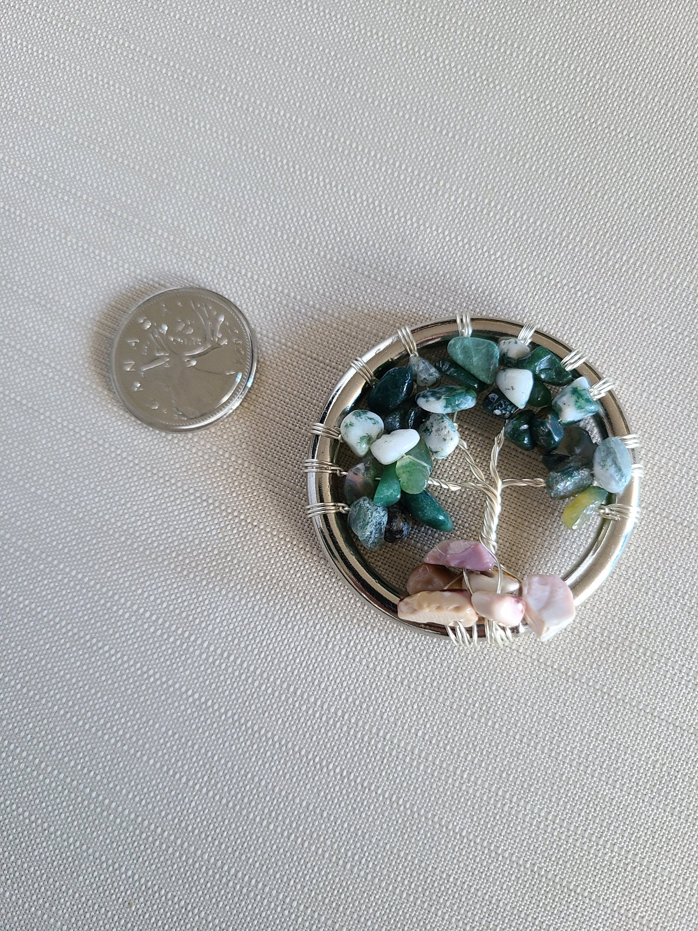 Small woven basket with colorful stones next to a coin on a light gray background