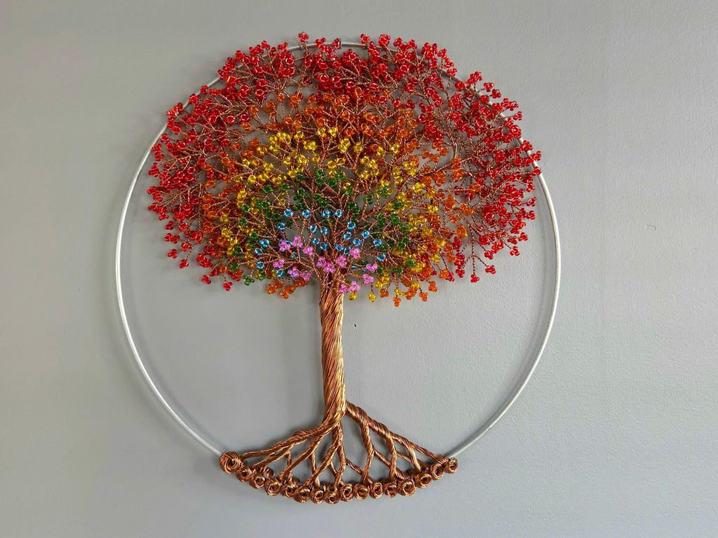Decorative wall art of a tree with colorful leaves on a plain background
