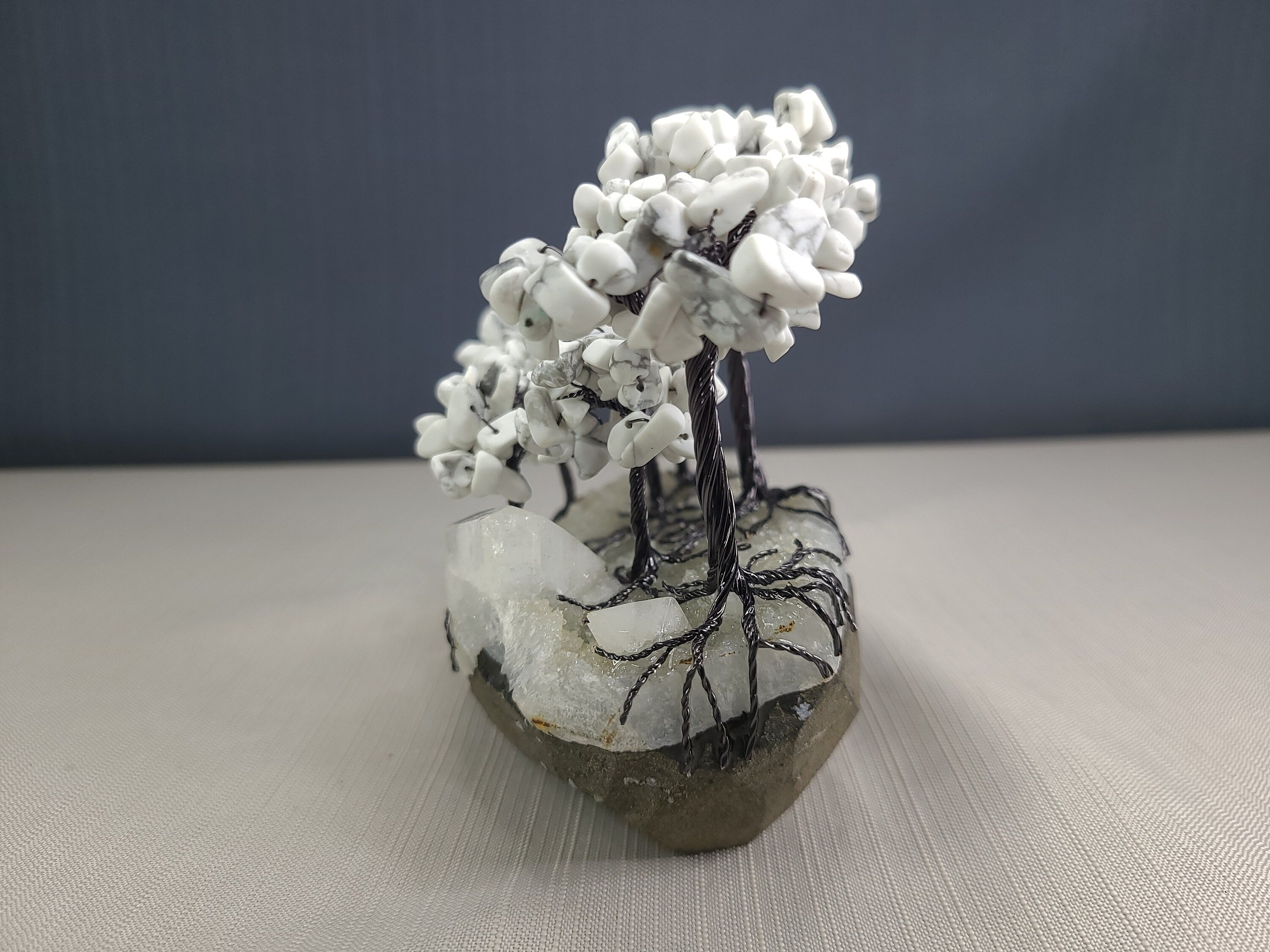 Mineral sculpture resembling a bonsai tree on a plain background