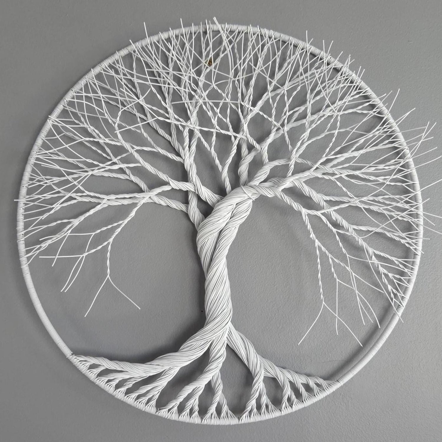 Decorative wall art of a tree with roots and branches on a gray background
