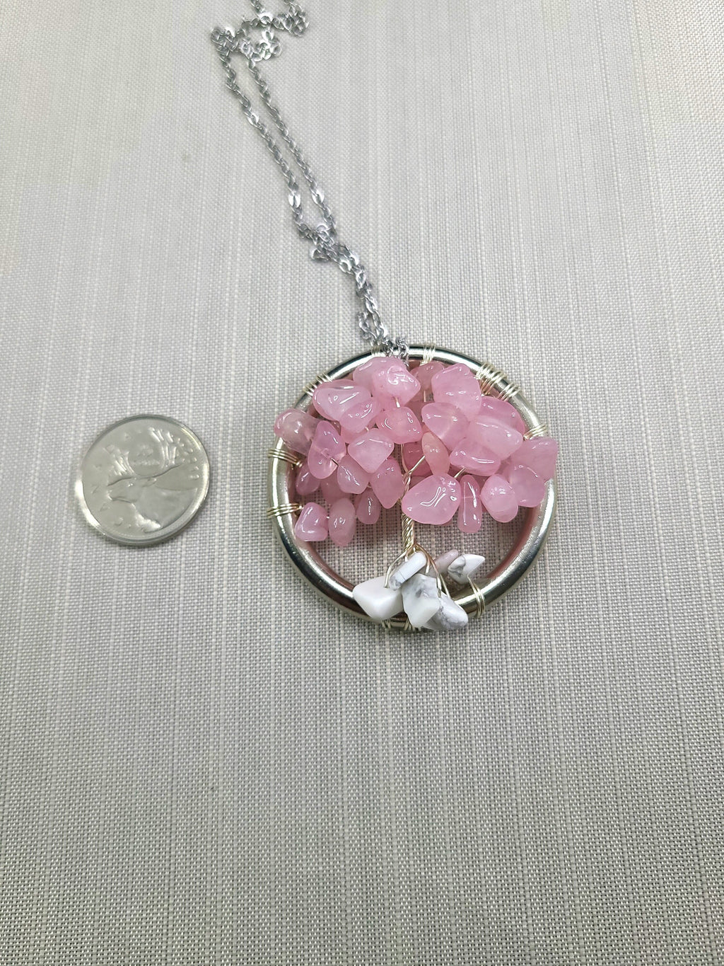 Necklace with pink stone pendant on a light gray background