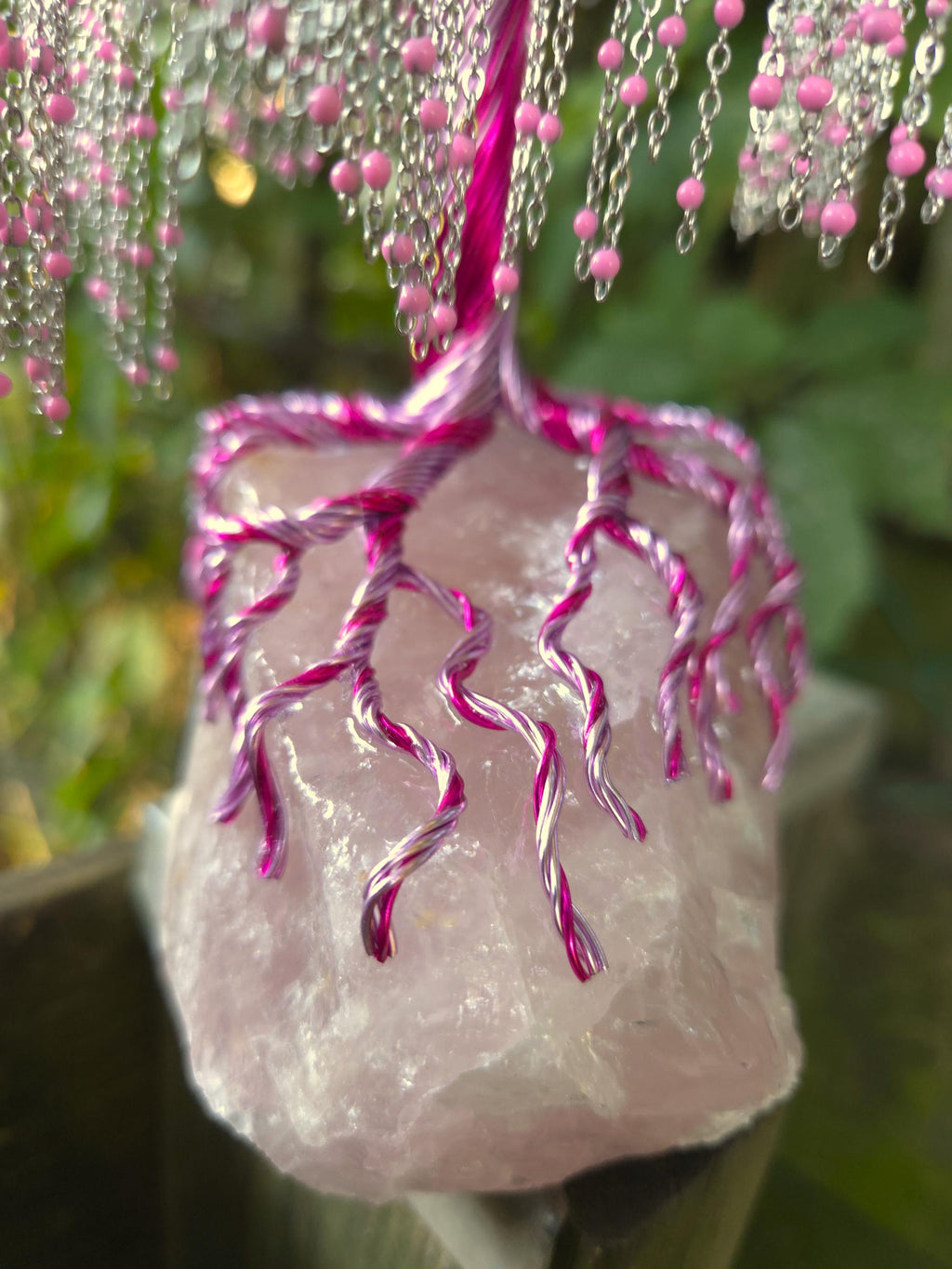 Decorative pink and silver ornament on a blurred natural background