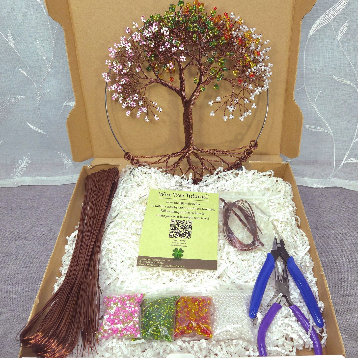 Wire tree art kit with materials and tools in a cardboard box.