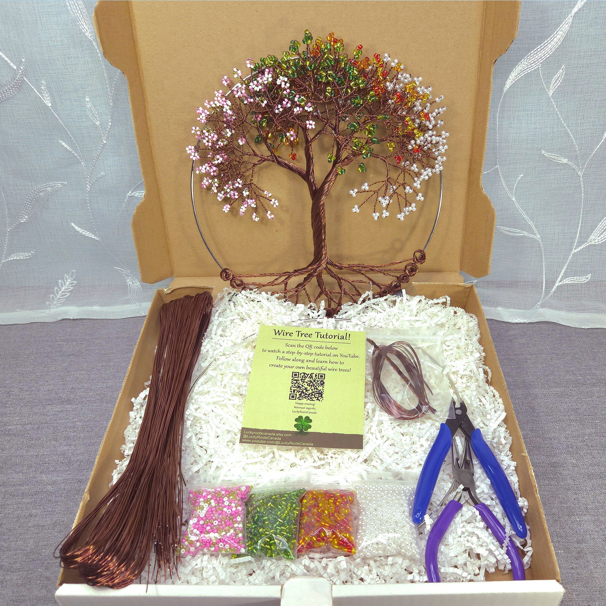 Wire tree art kit with materials and tools in a cardboard box.