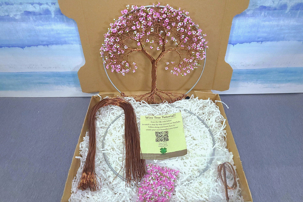 Decorative wire tree with pink beads in a box with a scenic background