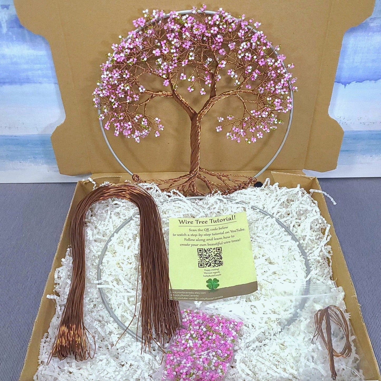 Decorative wire tree with pink beads in a box with a scenic background