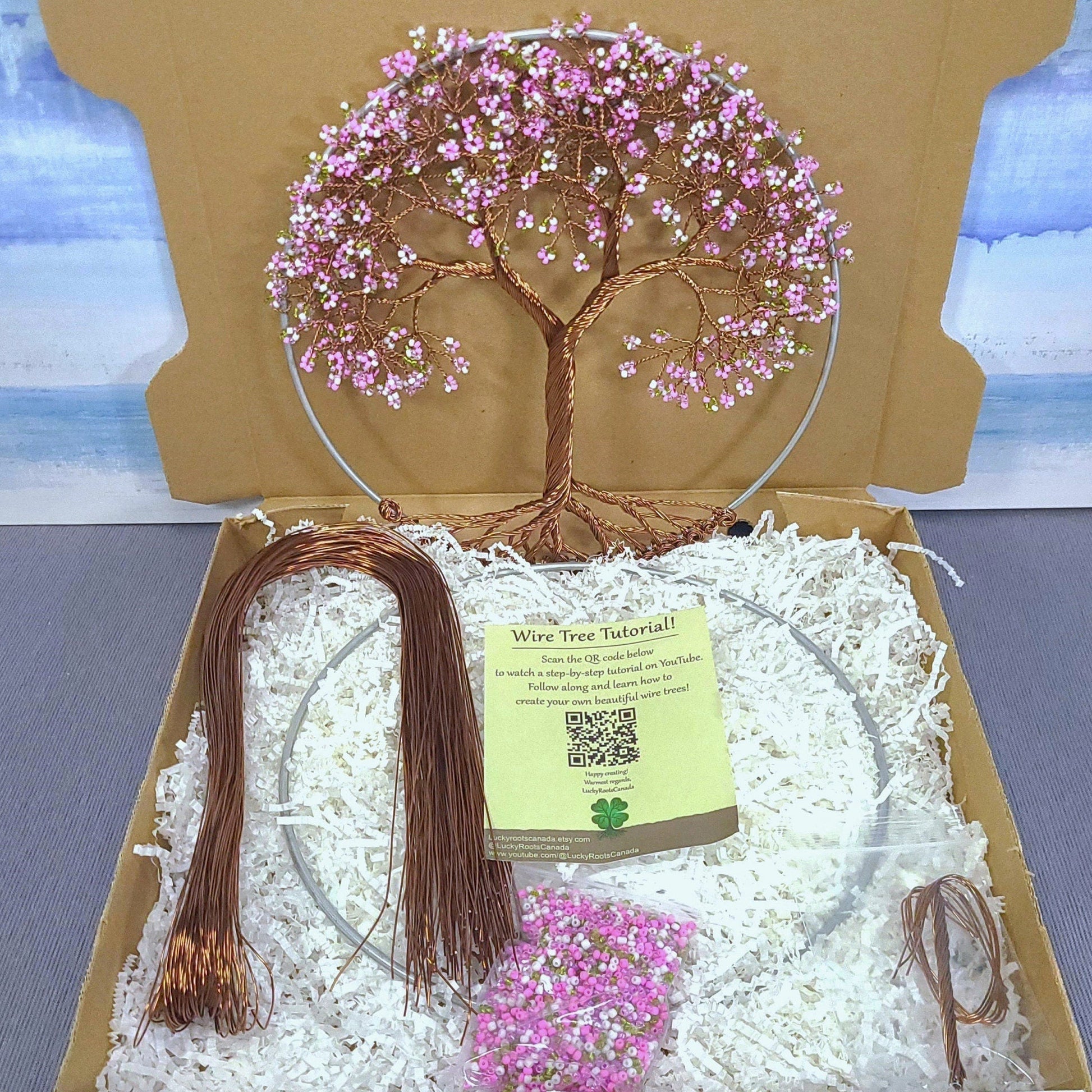 Decorative wire tree with pink beads in a box with a scenic background