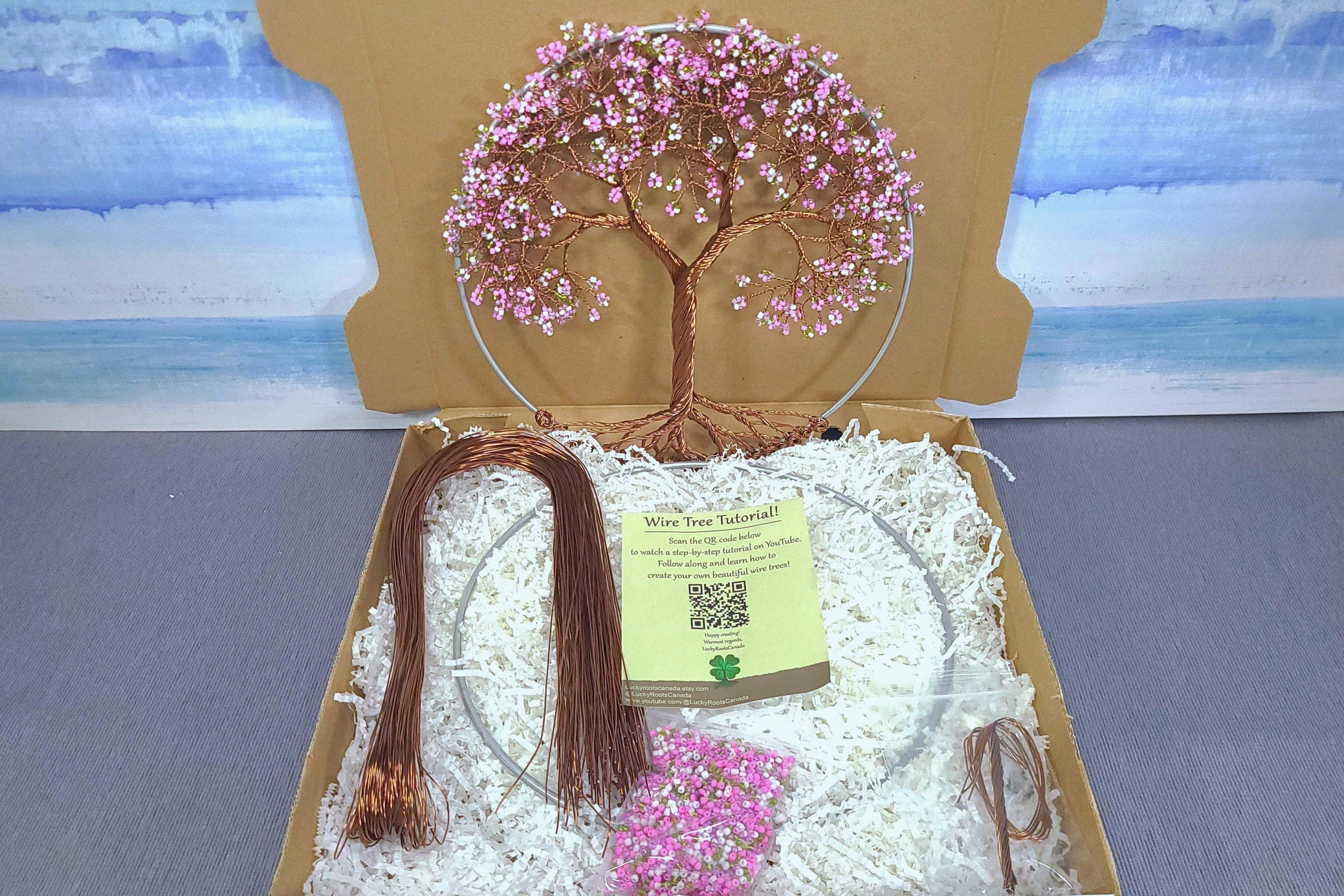 Decorative wire tree with pink beads in a box with a scenic background