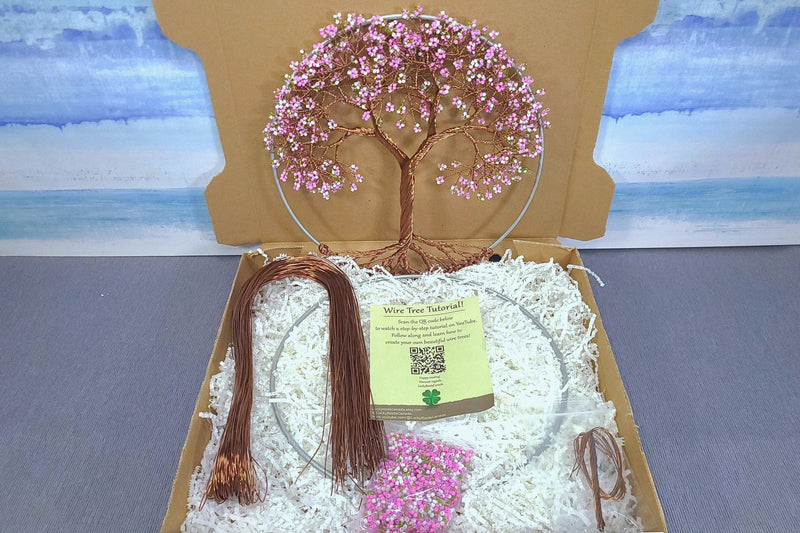Decorative wire tree with pink beads in a box with a scenic background
