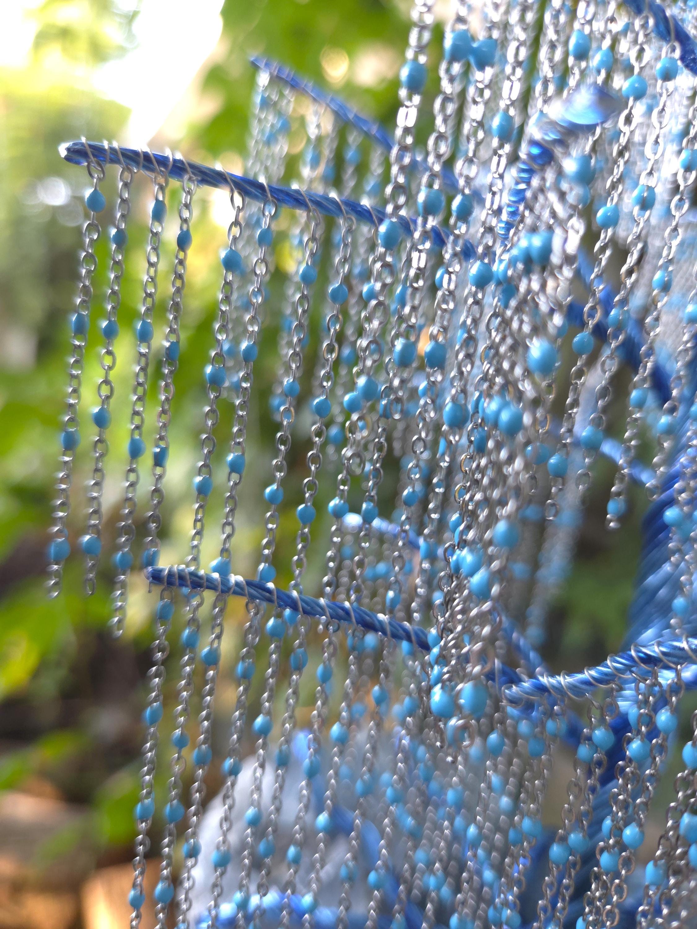 Blue beaded curtain with blurred green foliage in the background