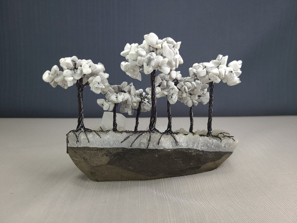 Decorative stone sculpture of a landscape with trees on a plain background