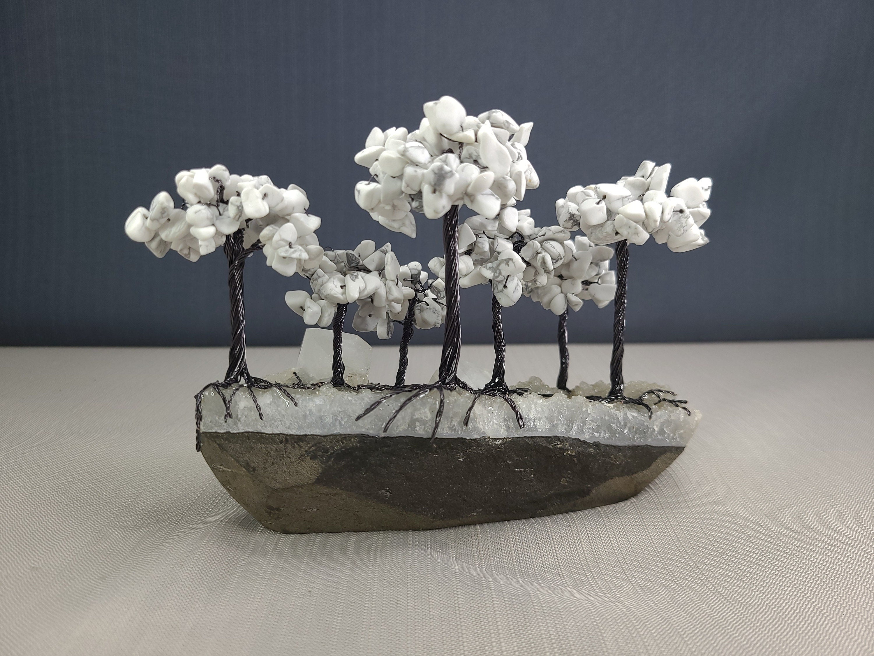 Decorative stone sculpture of a landscape with trees on a plain background