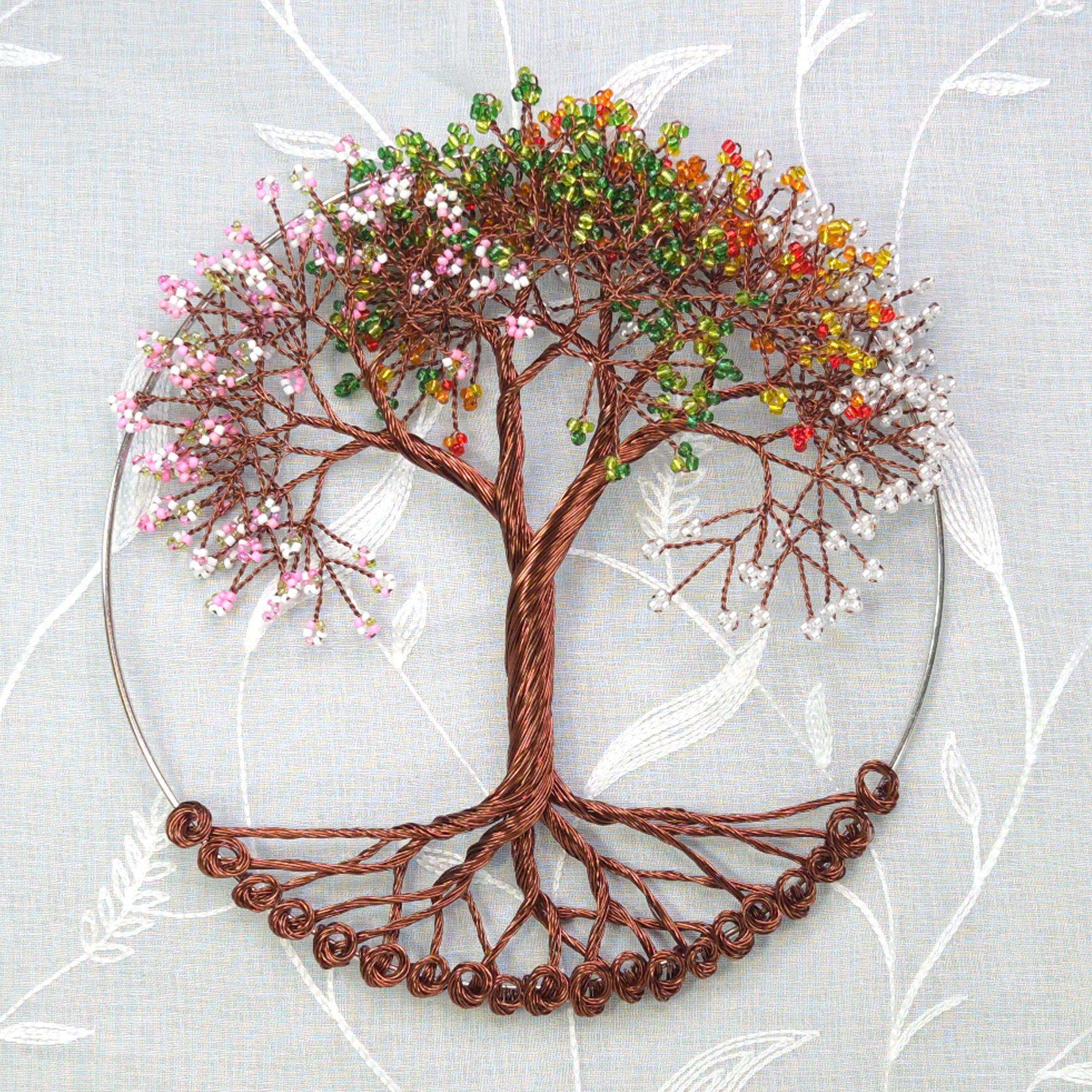 Decorative wire tree with colorful beads on a light gray background