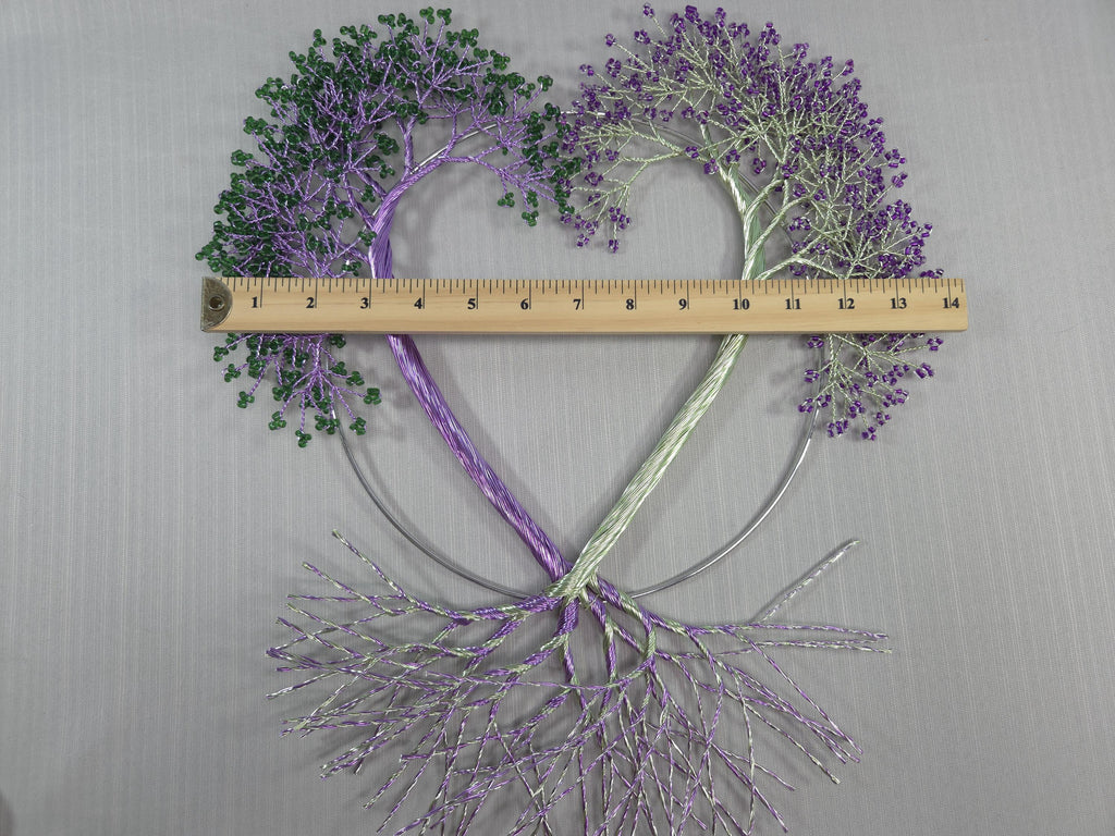 Decorative heart-shaped arrangement with purple and green elements, measured against a ruler on a gray background.