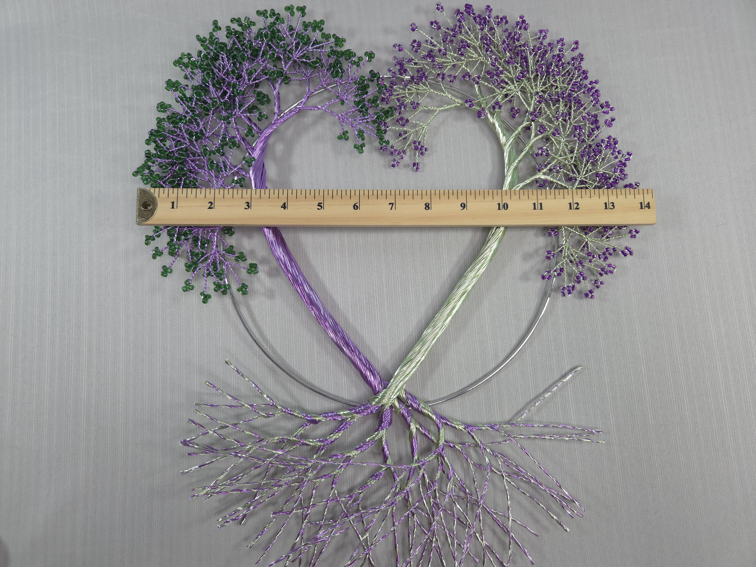 Decorative heart-shaped arrangement with purple and green elements, measured against a ruler on a gray background.