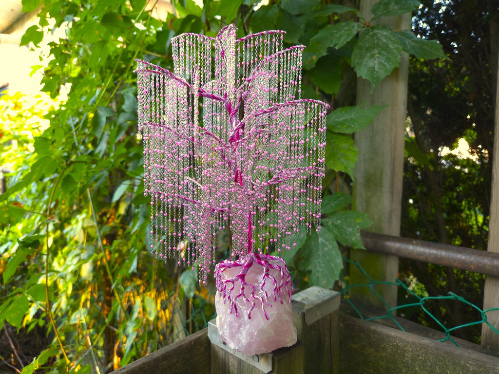 Decorative pink beaded tree in a pot against a natural background