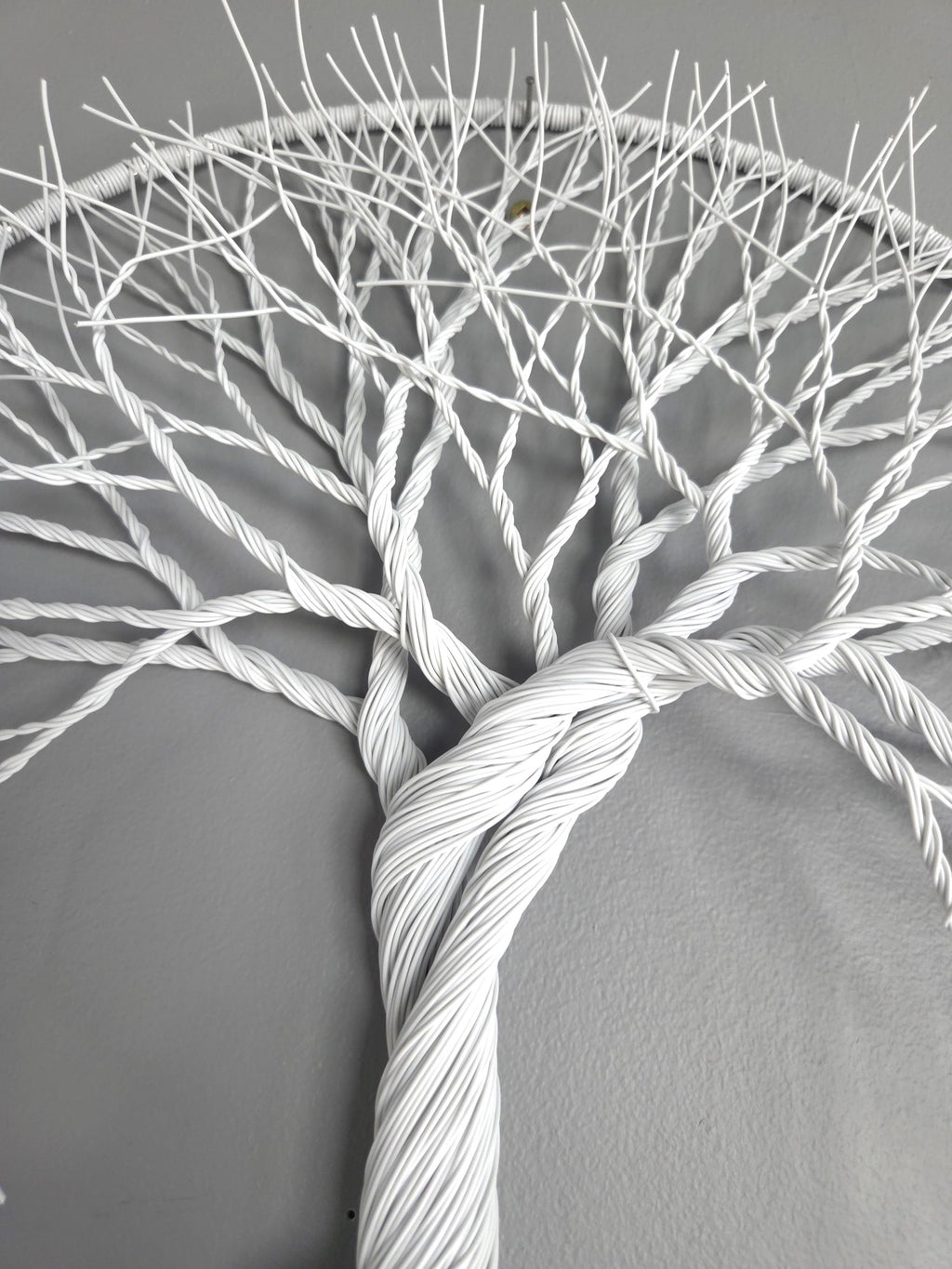 Artistic depiction of a tree made from twisted white cables on a gray background