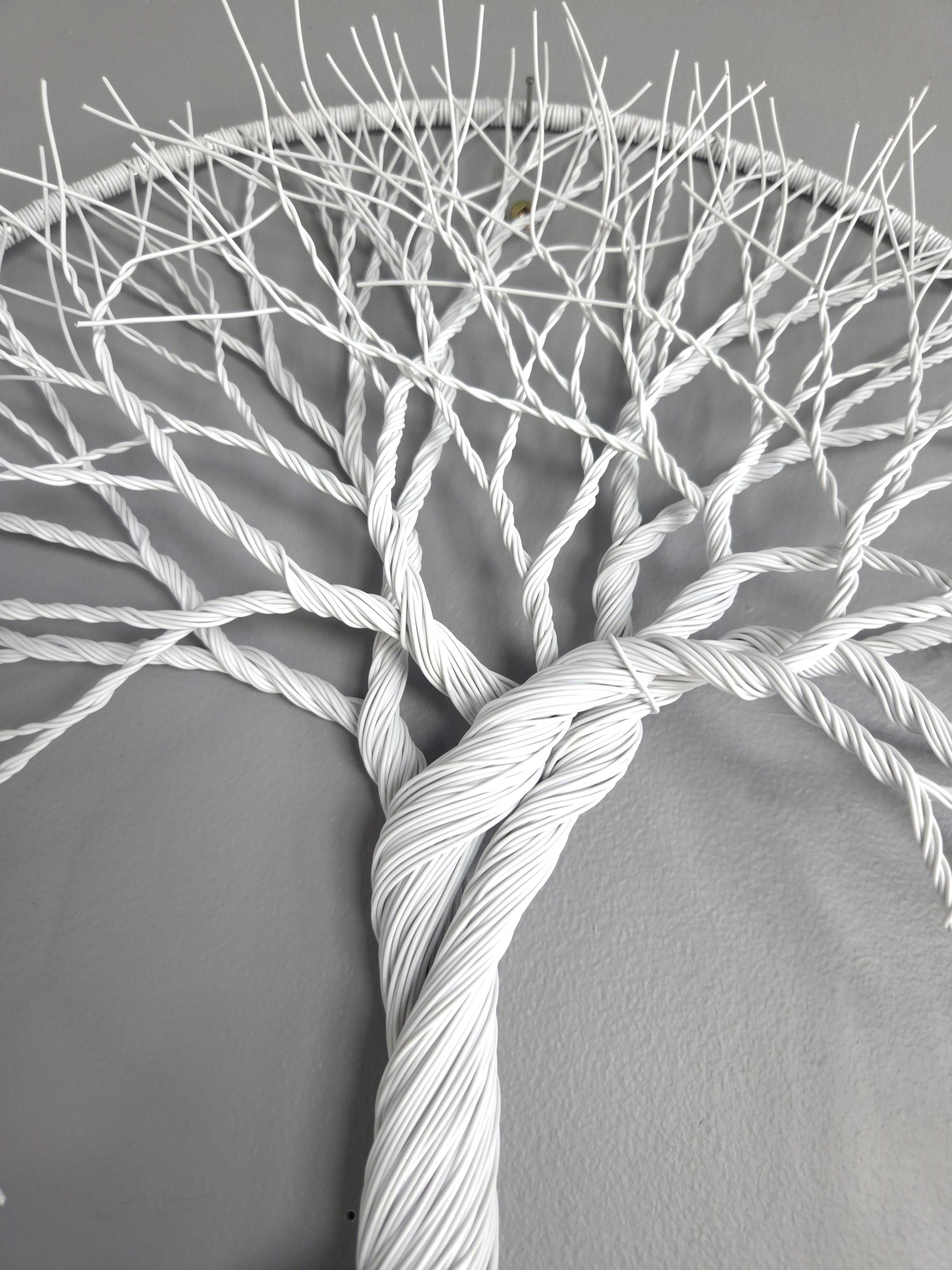 Artistic depiction of a tree made from twisted white cables on a gray background