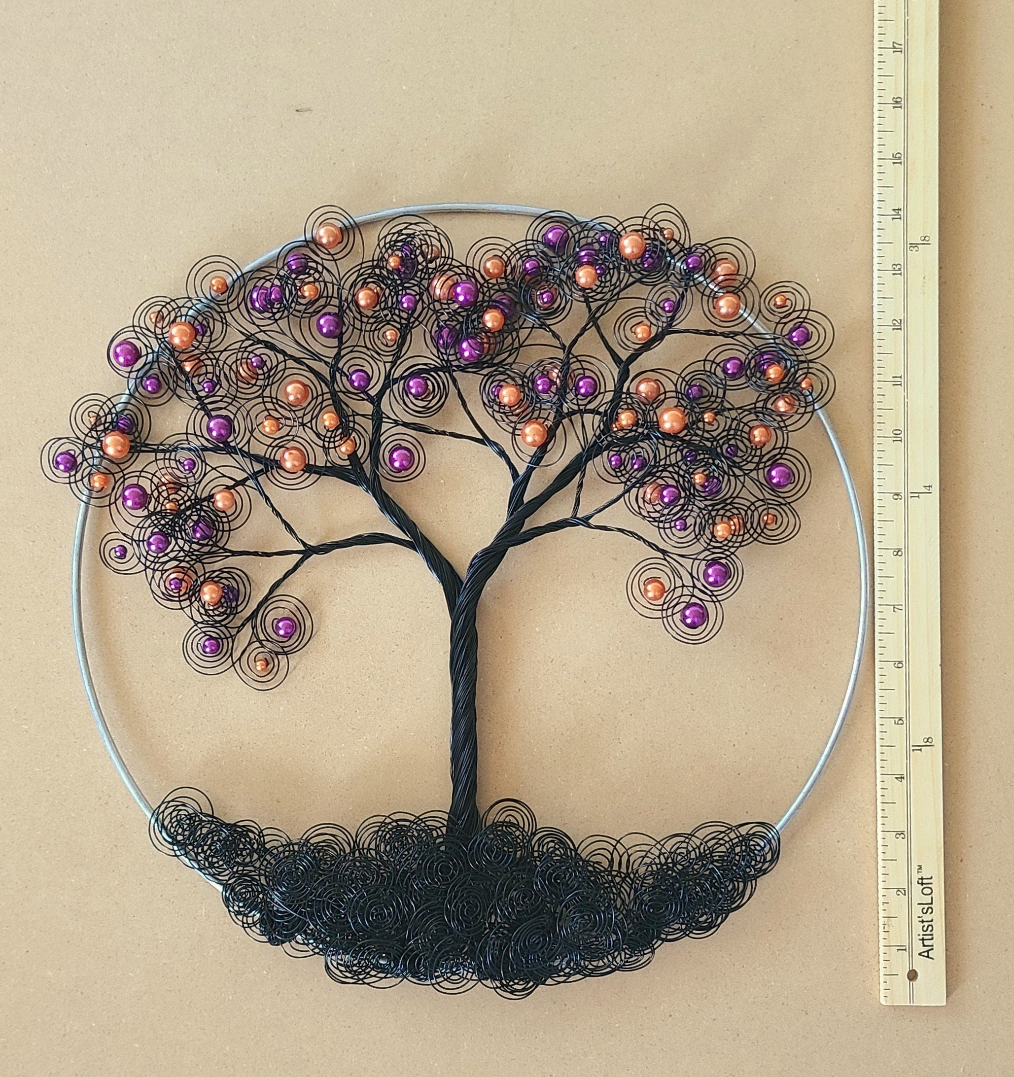 Decorative metal tree wall art with colored beads on a beige background, accompanied by a ruler for scale.