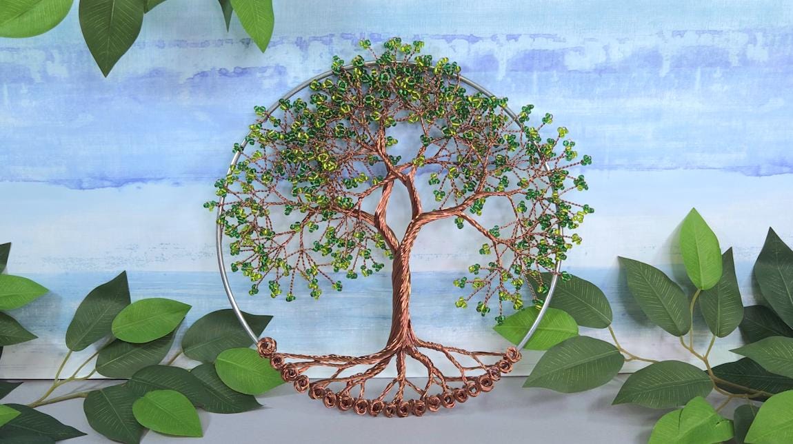 Decorative wall art of a tree with green leaves on a blue and white background