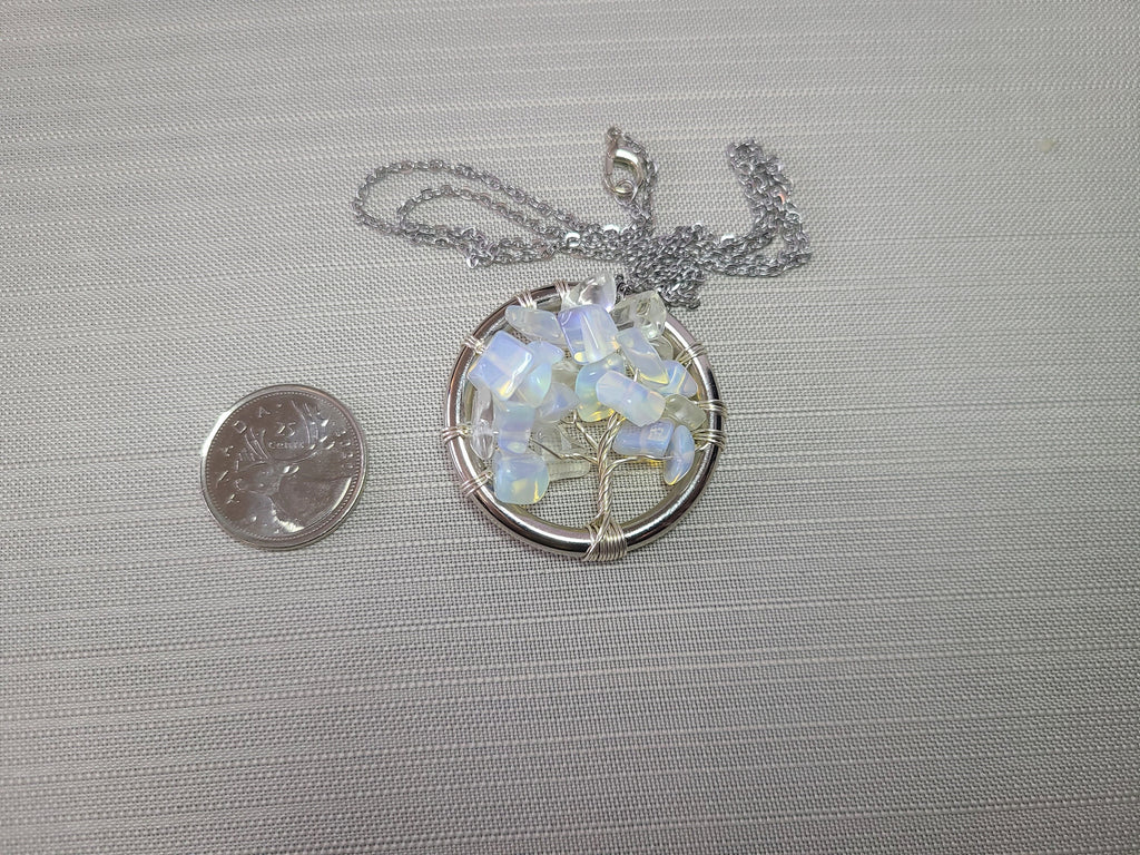 Opalite tree of life pendant with chain on a gray background