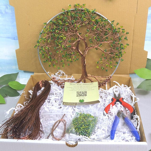 Box with a tree ornament, tassel, and tools on a scenic background