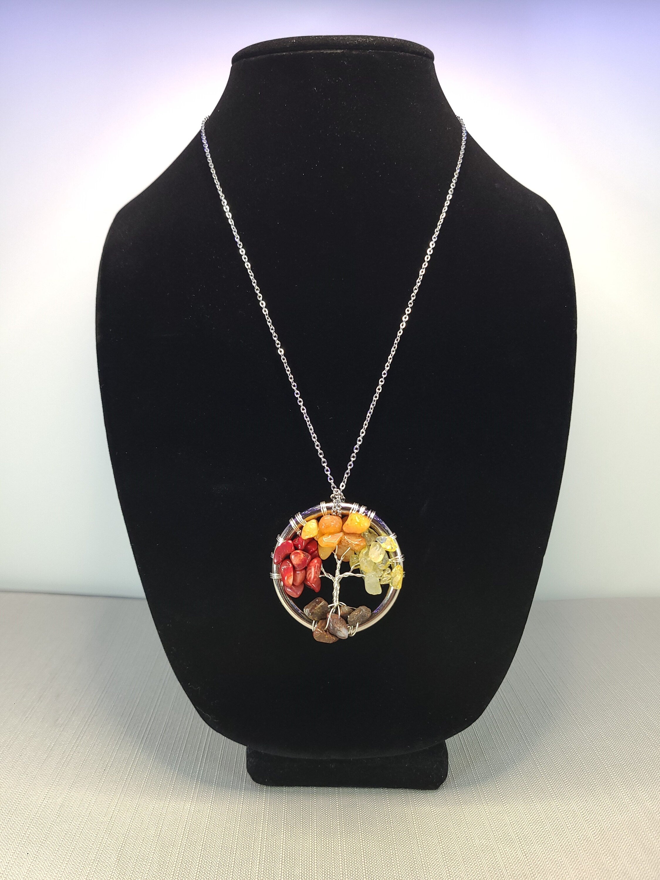 Necklace with a colorful pendant on a black bust against a white background