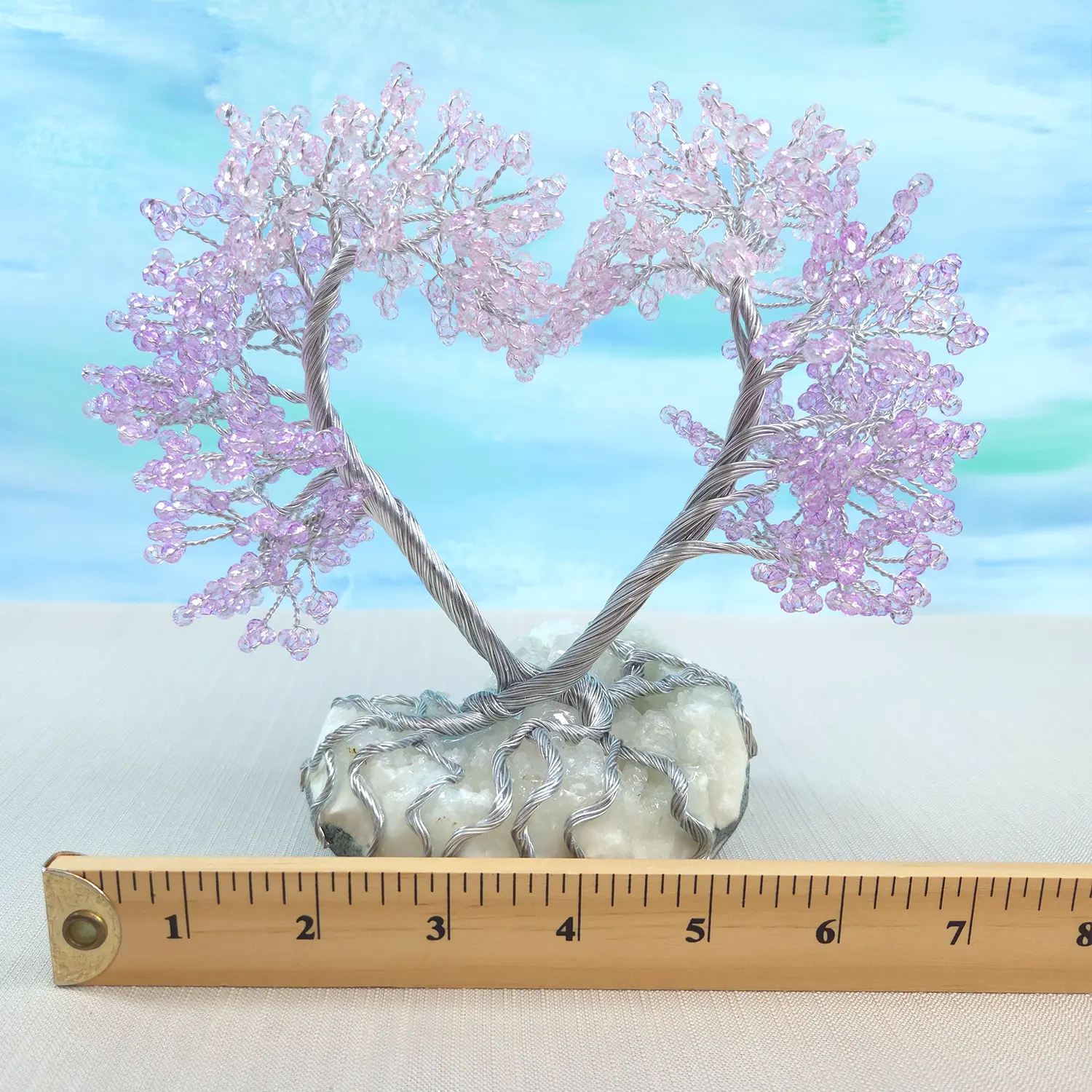 Decorative tree with pink beads on a white base, measured against a ruler for scale.
