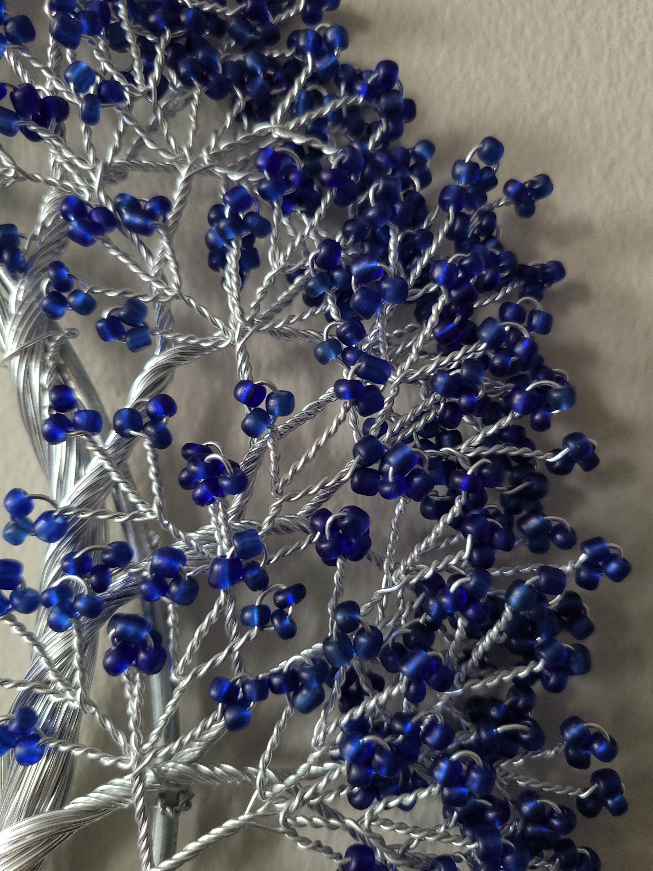 Decorative branch with blue berries on a neutral background