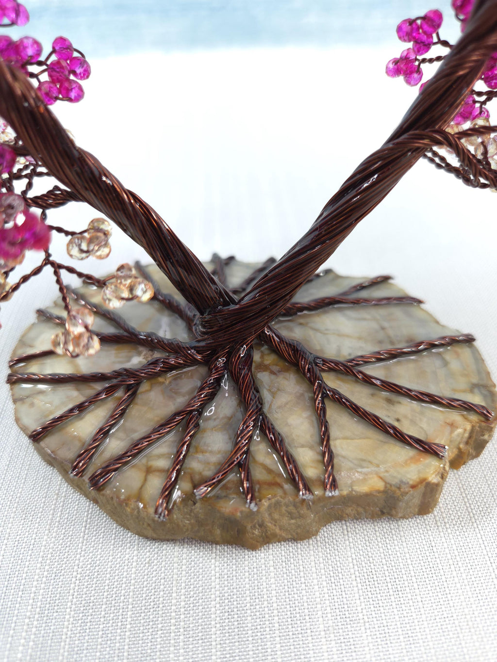 Decorative stone with wire and pink beads on a light background