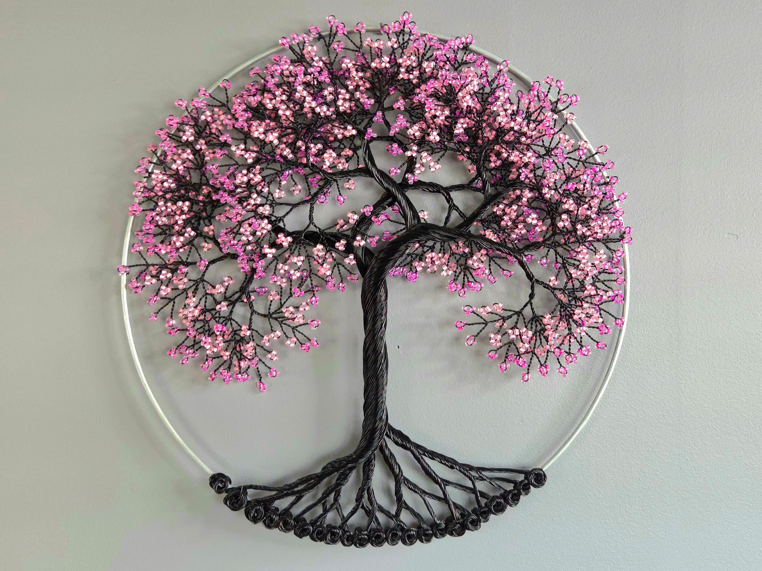Decorative wall art of a tree with pink blossoms on a gray background