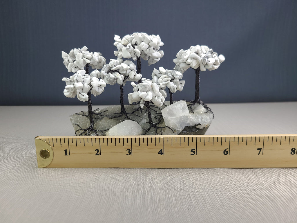 Mineral sculpture with a ruler for scale on a gray surface
