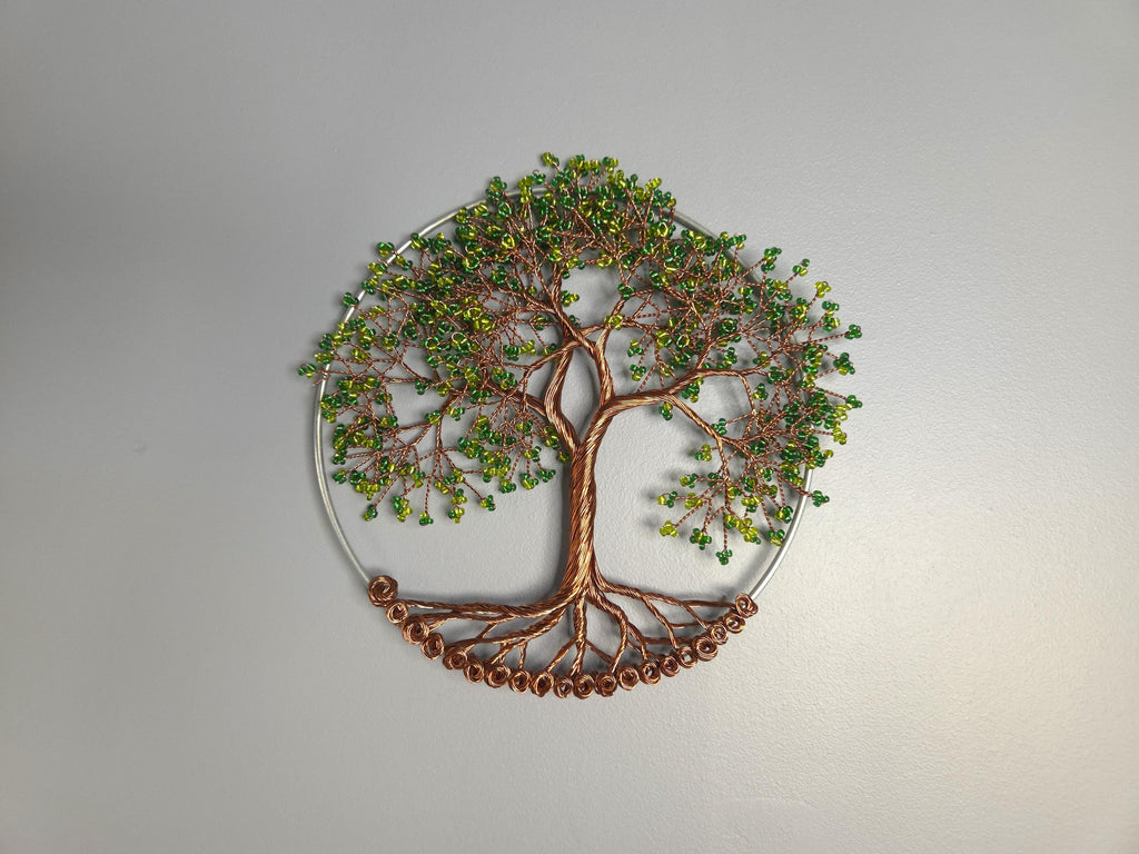 Decorative wall art of a tree with green leaves on a gray background