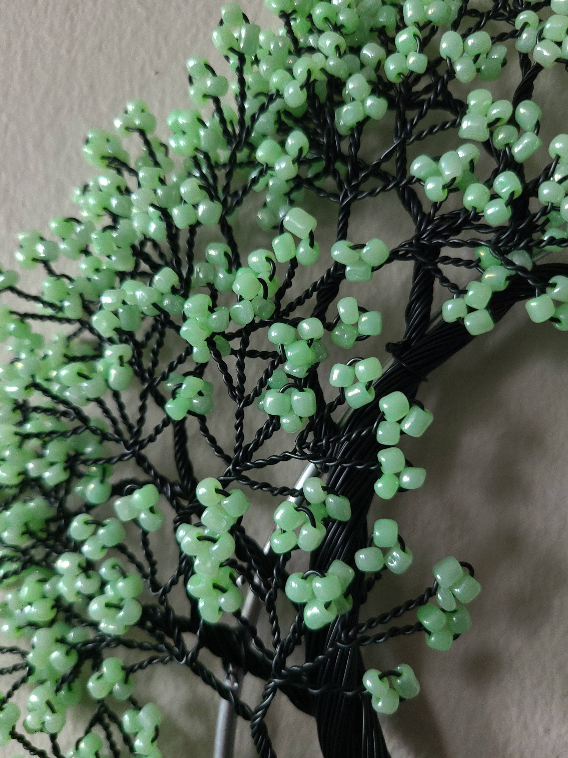 Decorative branch with green beads on a neutral background