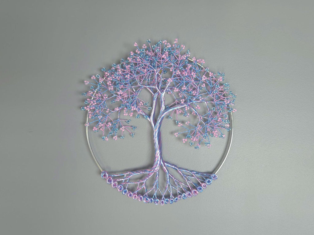 Decorative tree wall art with pink and blue branches on a gray background