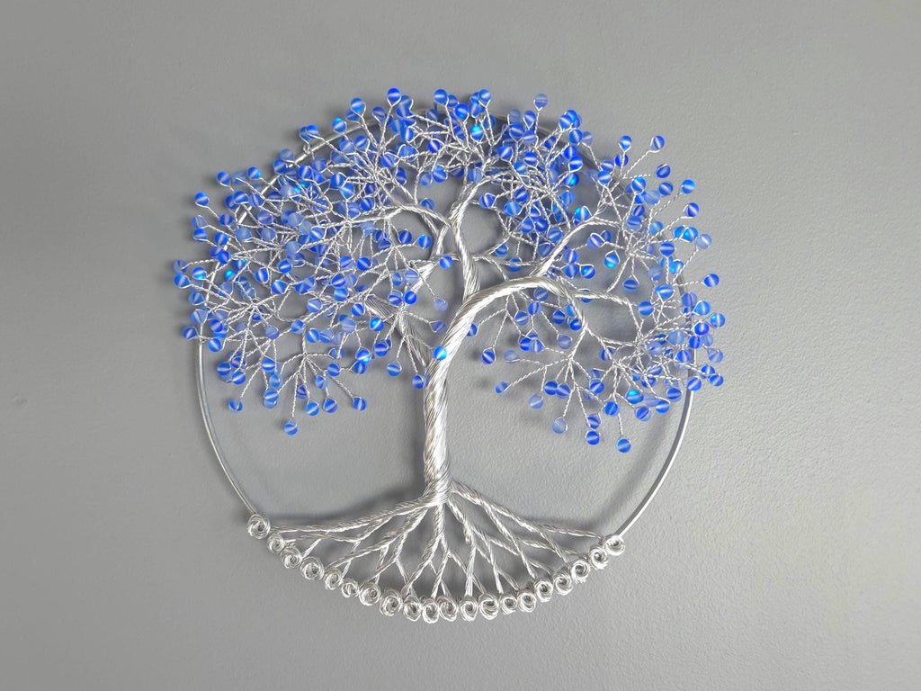 Decorative wall art of a tree with blue beads on a gray background