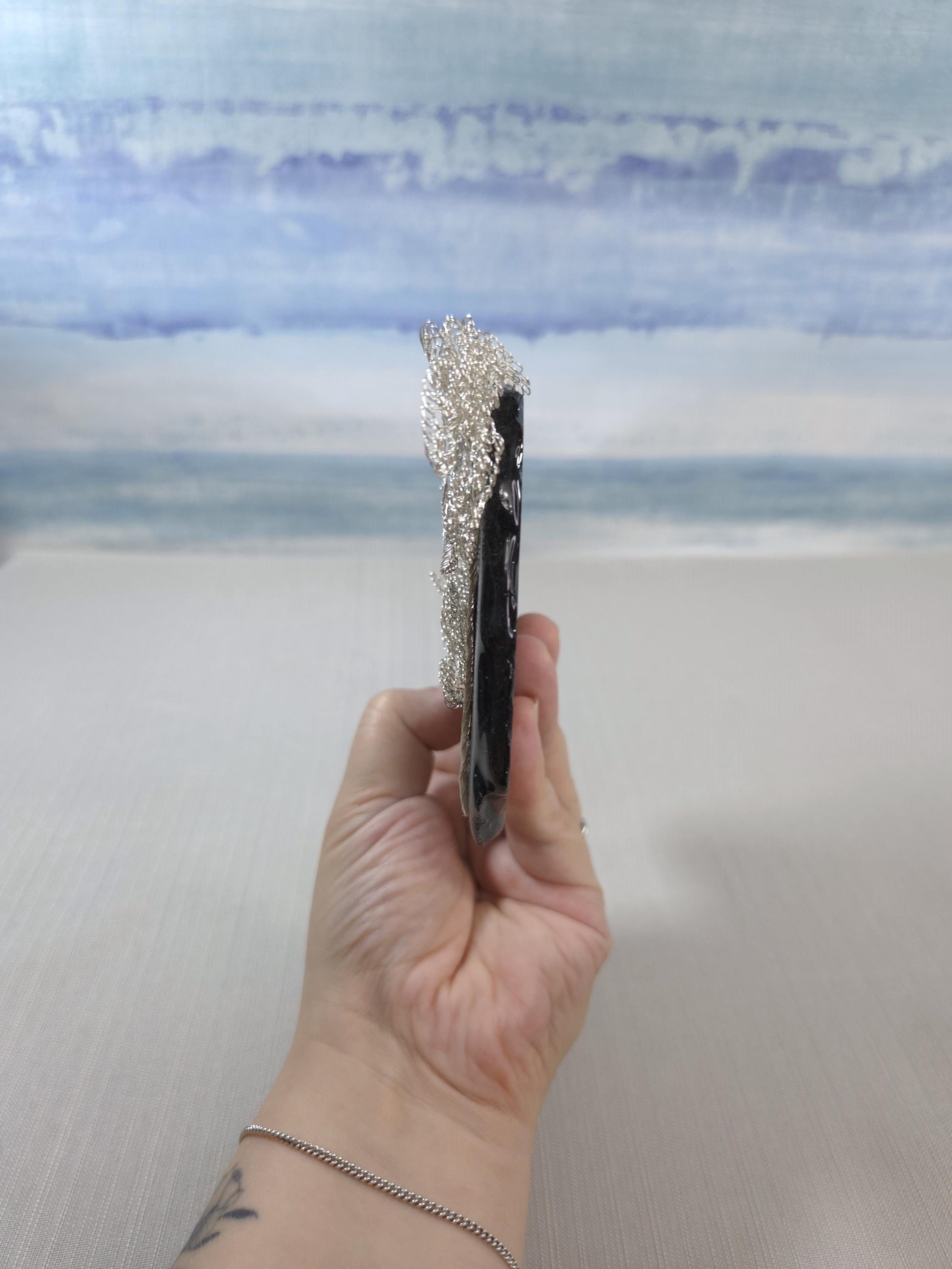 Hand holding a hairbrush with a blurred background