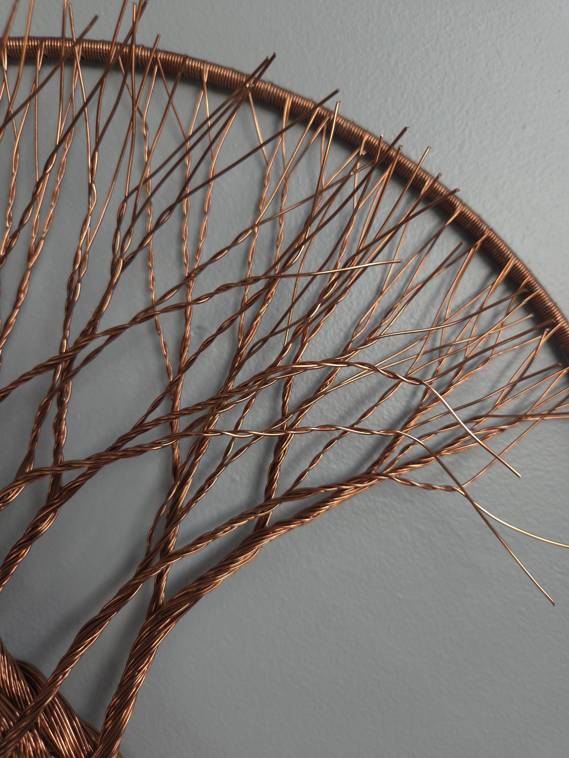 Decorative wall art made of interwoven branches on a gray background