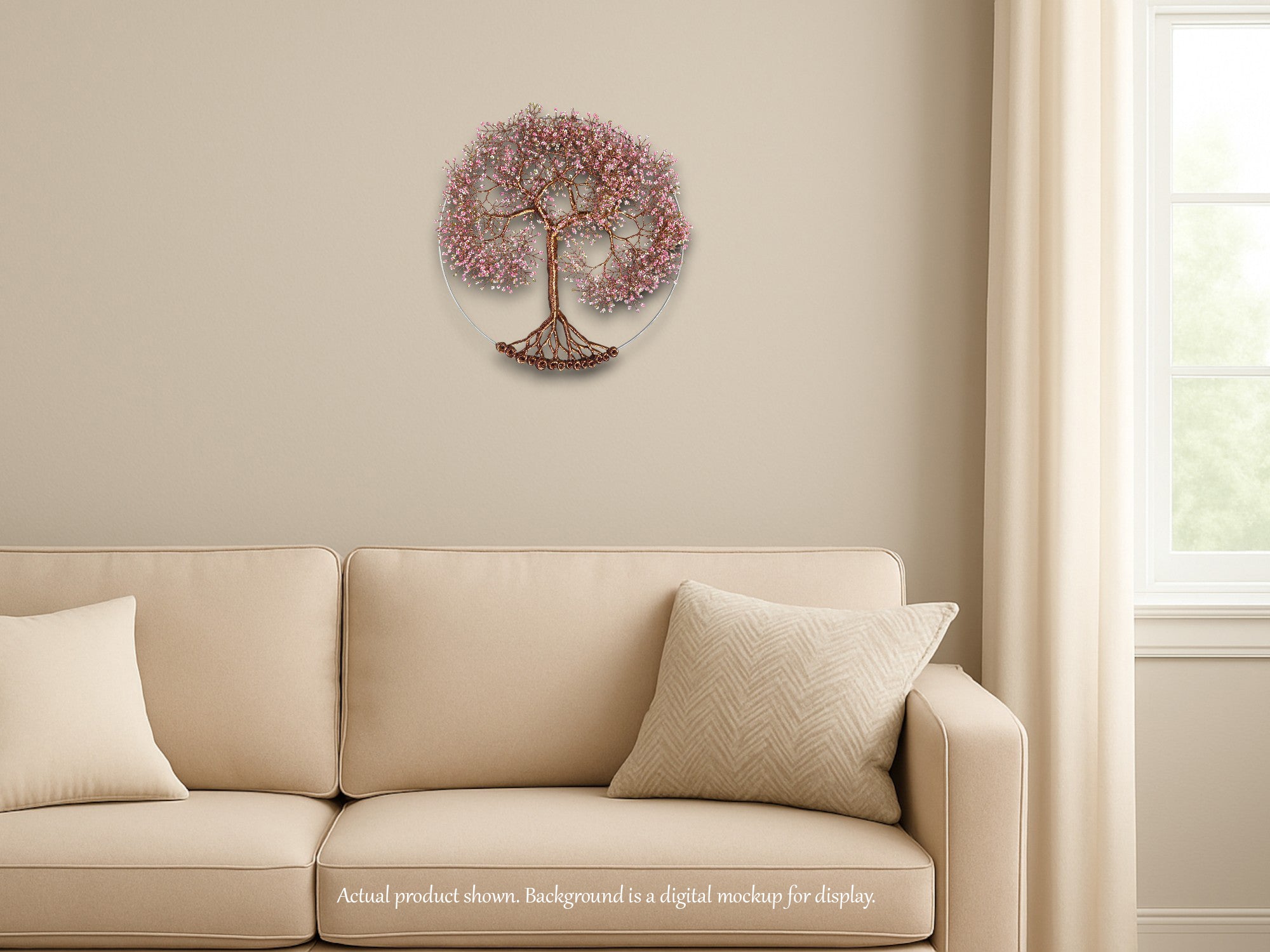 Decorative wall art of a tree with pink blossoms on a beige wall above a beige sofa.