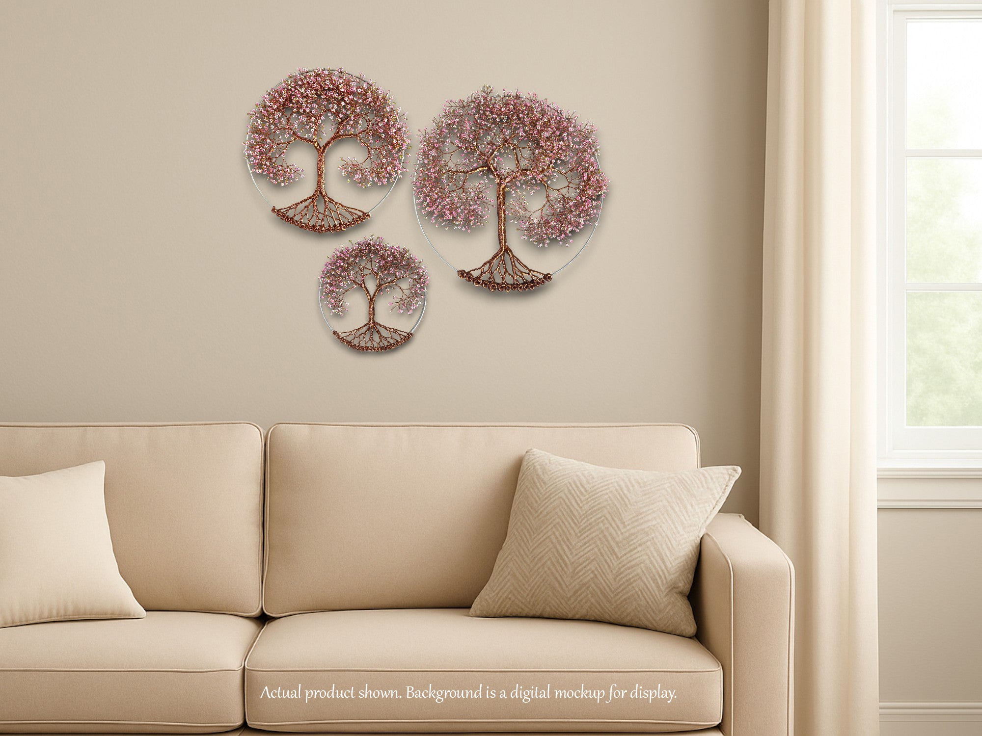 Decorative wall art of trees with pink blossoms above a beige sofa.