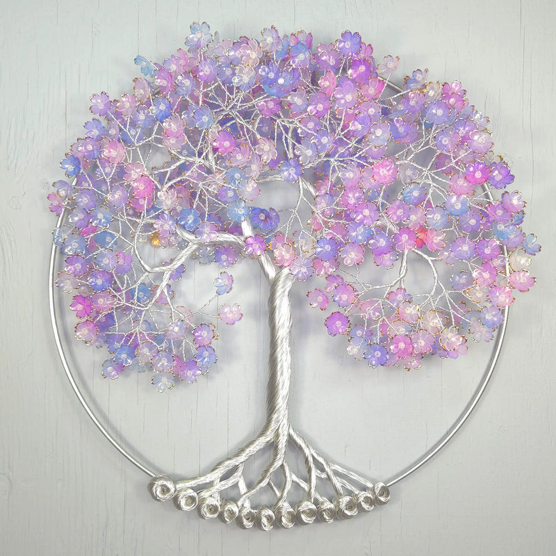 Decorative wall art of a tree with pastel-colored beads on a light gray background