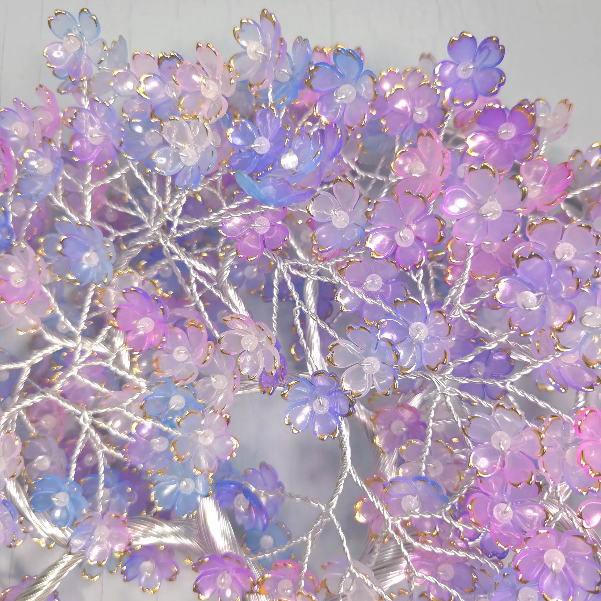 Decorative floral arrangement with purple, pink, and blue flowers on a light background