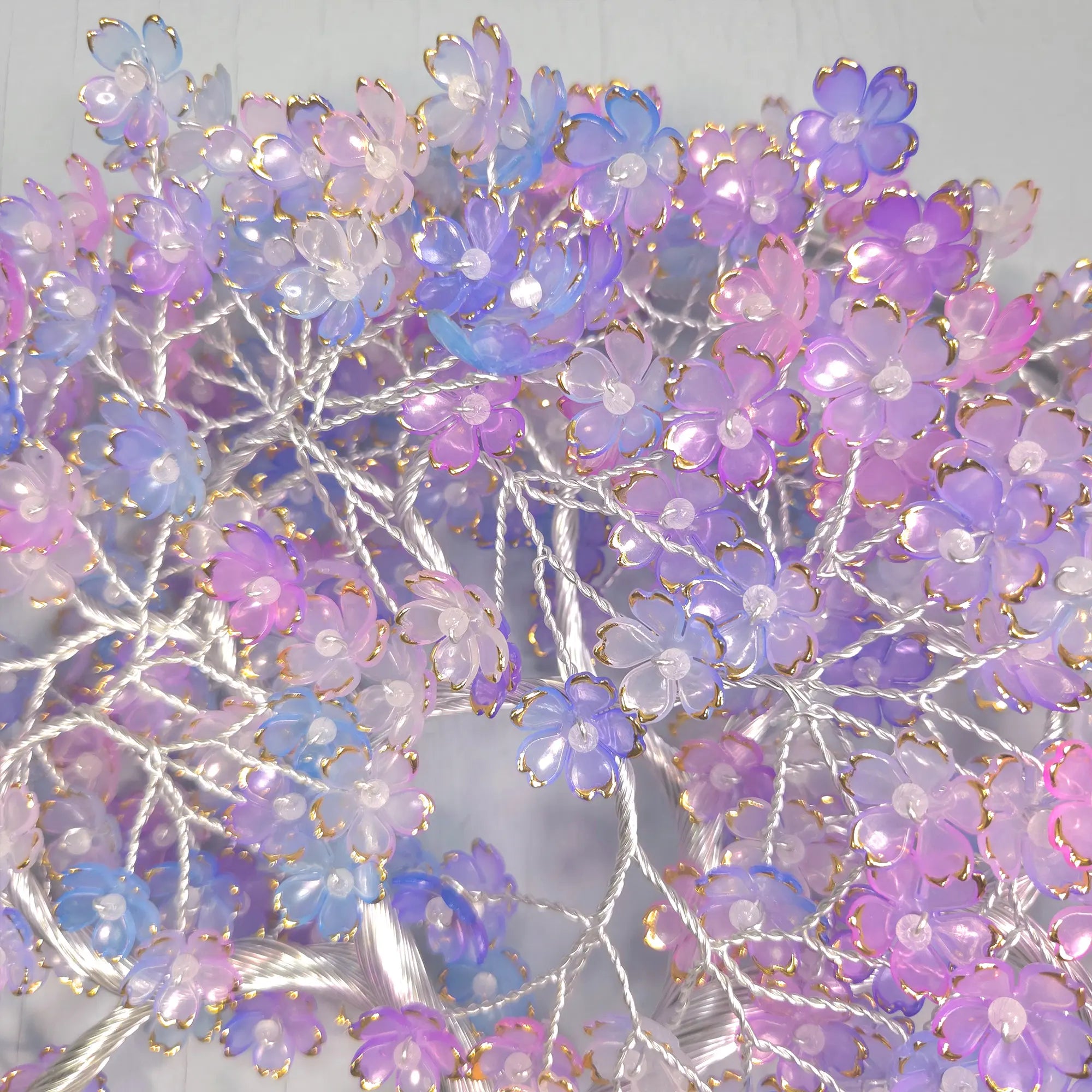 Decorative floral arrangement with purple, pink, and blue flowers on a light background
