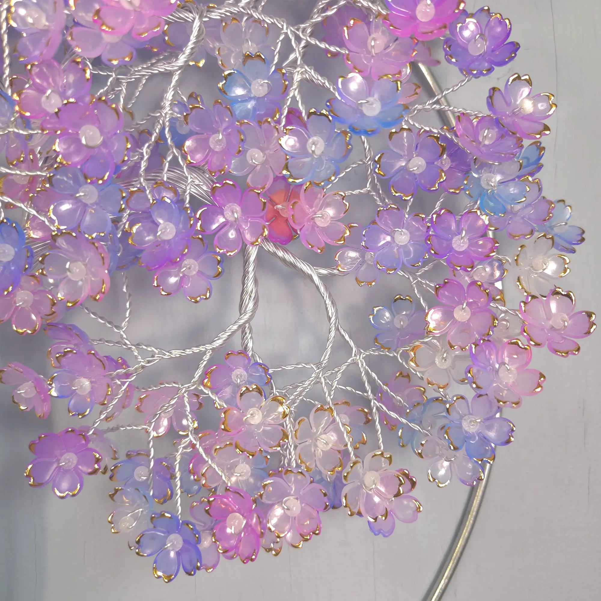 Decorative floral arrangement with pink and purple flowers on a gray background