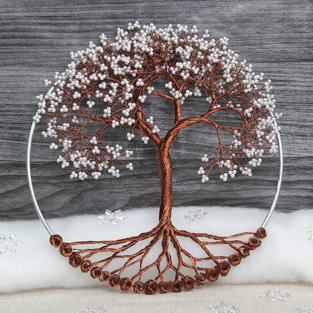 Decorative tree sculpture with brown branches and white berries on a gray wooden background.