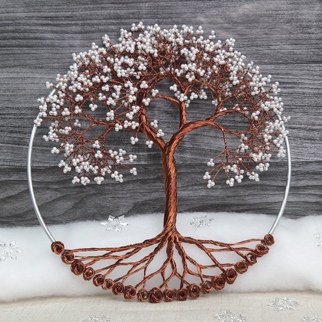 Decorative tree sculpture with brown branches and white berries on a gray wooden background.