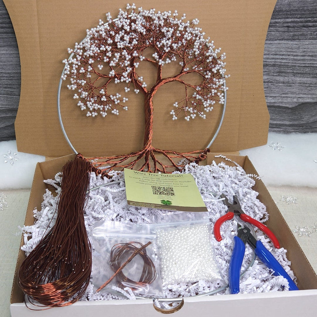 Craft kit with materials for making a wire art tree in a cardboard box.